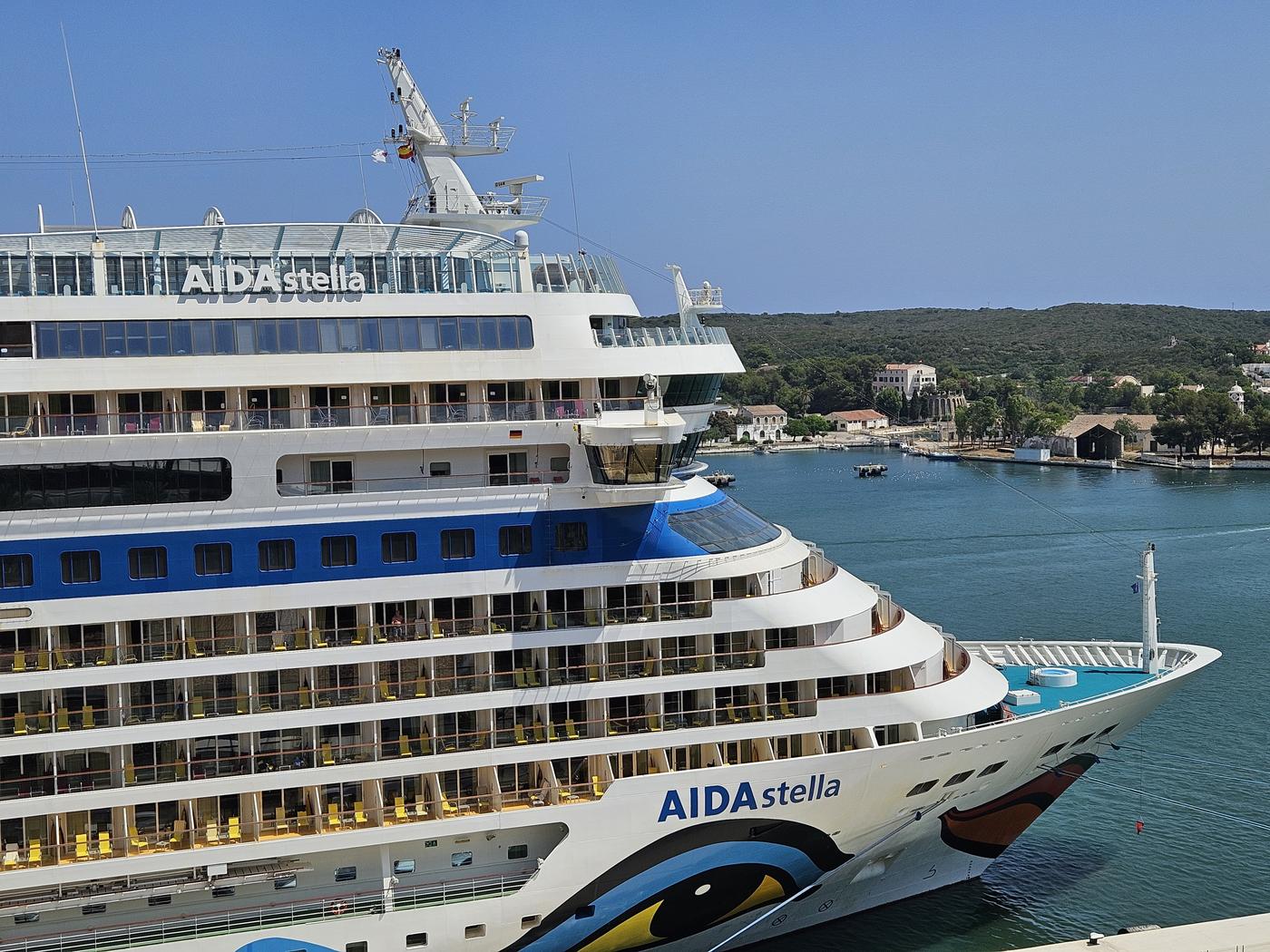 AIDA-Kreuzfahrtschiff liegt im Hafen vor Fjord-Kulisse